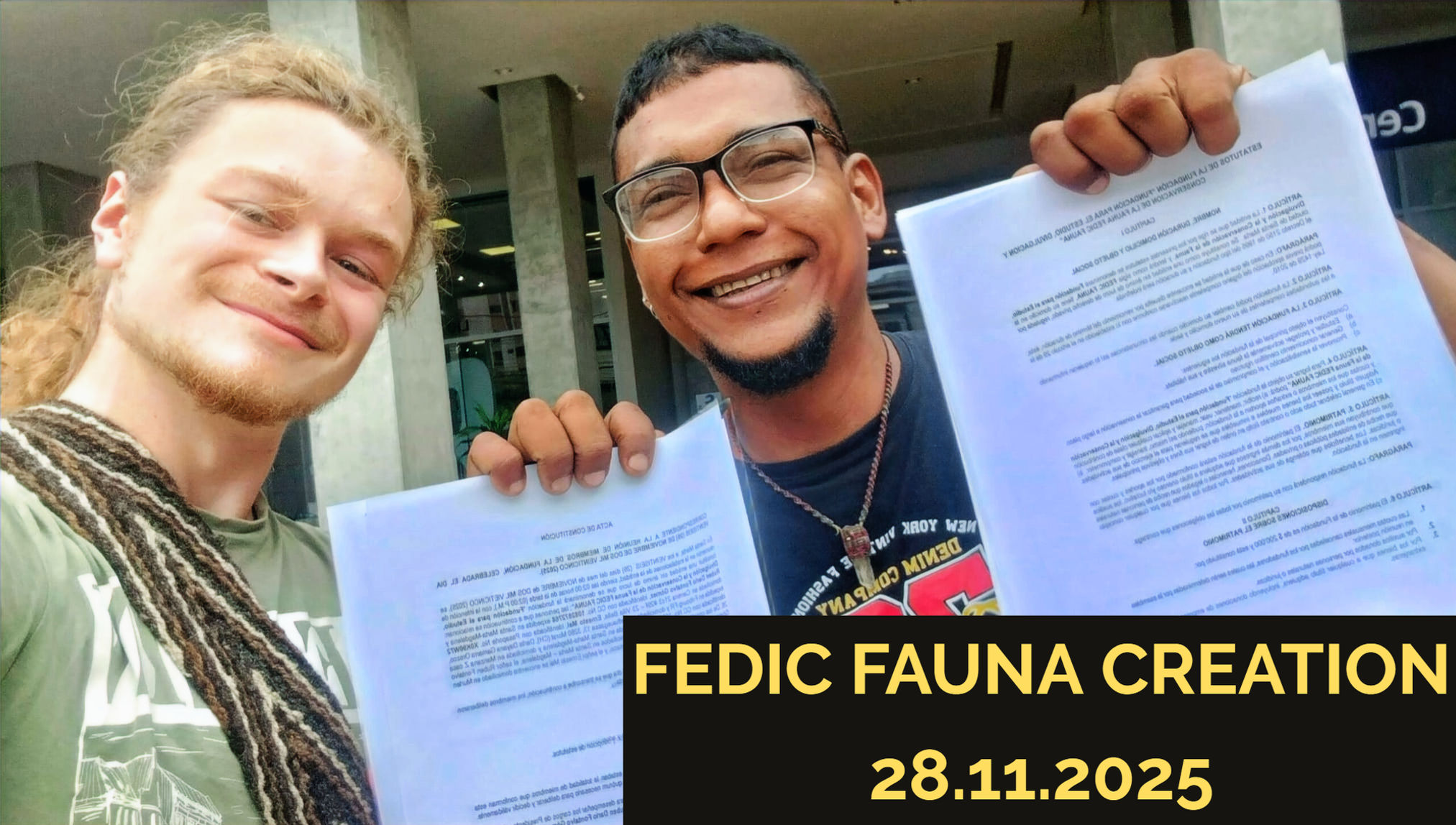 Two people holding documents, with the original caption FEDIC FAUNA creation